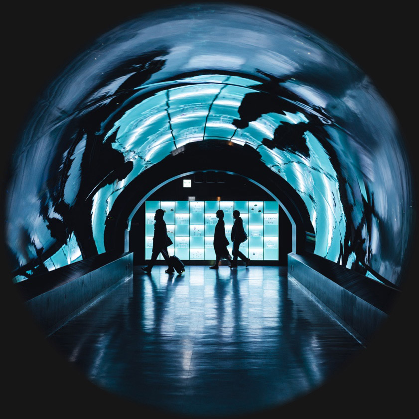 three travelers walk through a tunnel